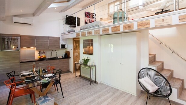 A spacious kitchen with a dining area, a staircase, and a loft bedroom with a view. - Superb loft apartment in the heart of old Antibes 3mns from the beach (Antibes)