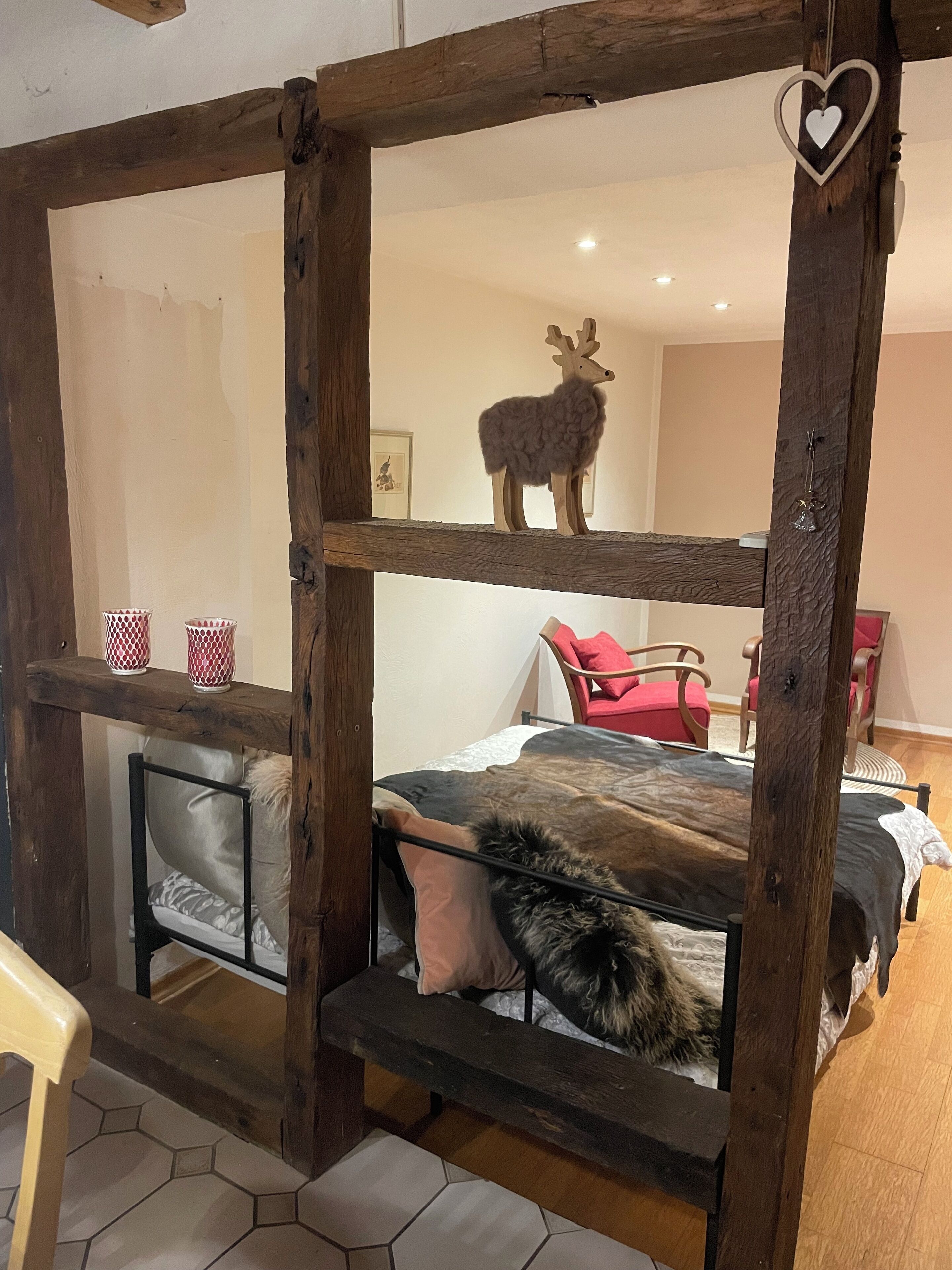 A rustic wooden bunk bed with a decorative deer head on the top bunk.
