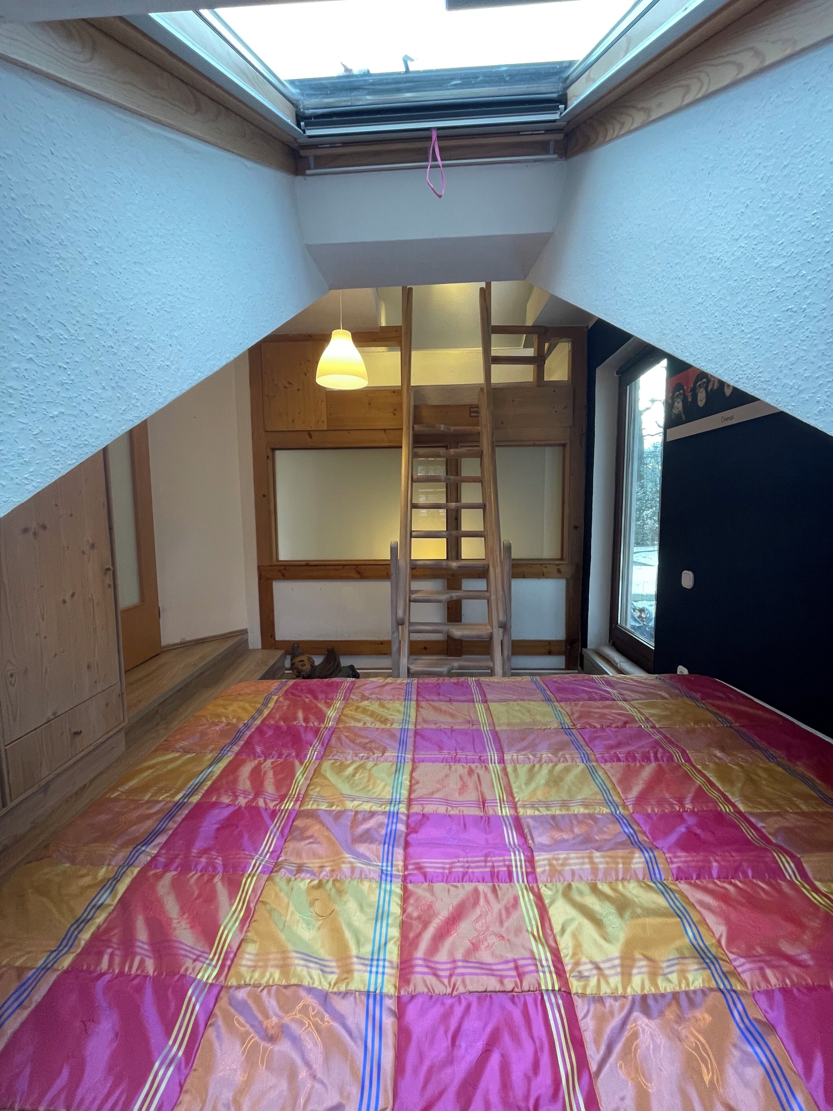 Ein Schlafsaalzimmer mit Hochbett, einer Halterung und einem Dachfenster.