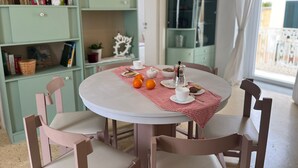 Une table ronde recouverte d’une nappe à carreaux rouges et blancs, entourée de quatre chaises.