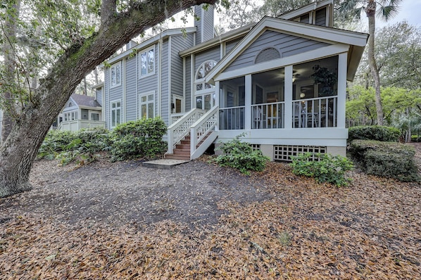 A two-story house with a covered porch and a staircase leading to the entrance.