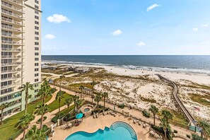 A hotel with a pool, beach access, and a view of the ocean.
