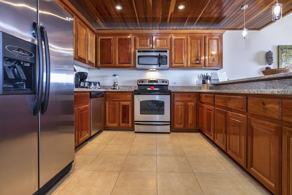 A kitchen with wooden cabinets, stainless steel appliances, and a granite countertop.