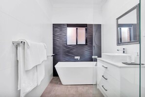 Bathtub, hair dryer, towels, shampoo