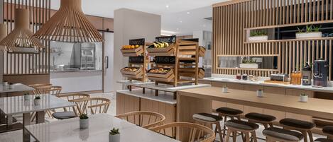 A modern kitchen with wooden accents, a central island with stools, and a breakfast bar.