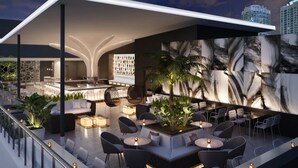 A modern outdoor lounge area with seating, a bar, and a large wall mural. - Element by Marriott Miami Brickell (Miami)