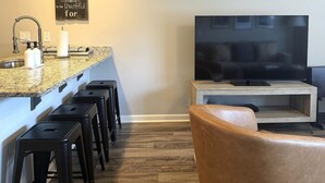 A kitchen with a granite countertop, a built-in stove, and a bar stool area. - Walk to Toomer's! Ground-Floor 4 BR Auburn Condo (Auburn)