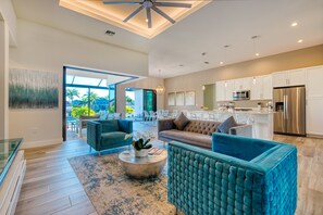Amplia sala de estar con cocina moderna, asientos confortables y un ventanal con vistas al exterior.