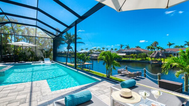 Un espace piscine avec une eau d’un bleu limpide, des chaises longues et des parasols.