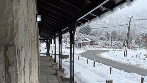 A covered walkway with stone walls and a snow-covered path.