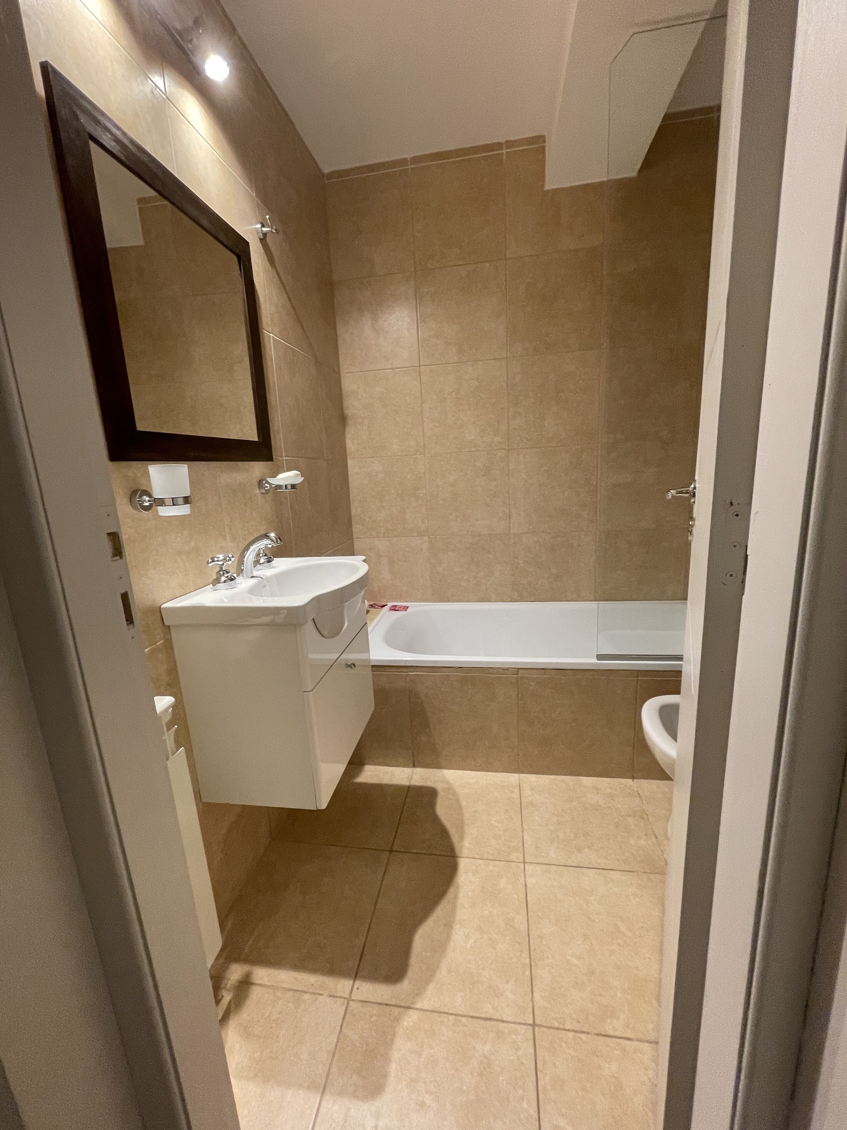 Une salle de bain avec un lavabo, un miroir et une baignoire.