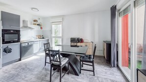 Une cuisine moderne avec une table et des chaises, un four encastré et un four à micro-ondes.