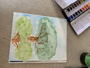 A watercolor painting of two trees on a textured surface.
