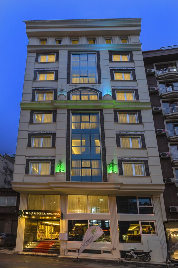 A multi-story hotel with a prominent entrance, large windows, and a flag outside. - Atro Hotel (Istanbul)