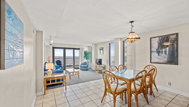 A spacious living area with a dining table, chairs, and a television.