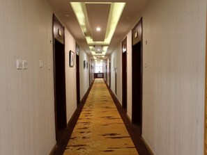 A hotel hallway with doors on both sides, a carpeted floor, and recessed lighting. - Greentree Alliance Hulunbeier Zhalantun Railway Station Hotel (Hulunbuir)