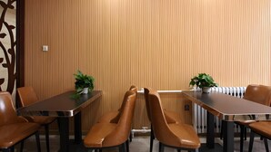 A conference room with a long table and six brown leather chairs. There are two potted plants on the table. - Greentree Alliance Hulunbeier Zhalantun Railway Station Hotel (Hulunbuir)