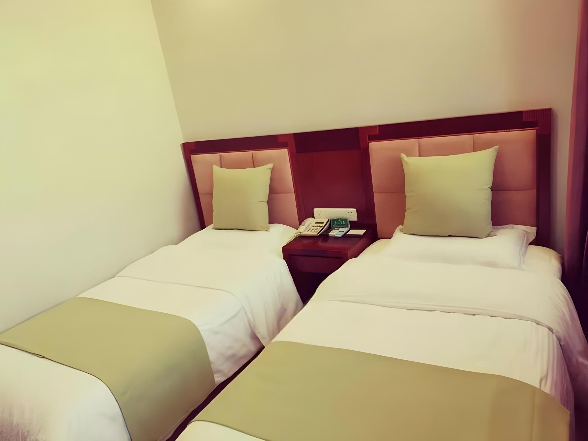 Hotellihuoneessa on kaksi erillistä sänkyä, joissa kummassakin on pääty ja tyyny. Sänkyjen välissä on yöpöytä, jossa on puhelin ja pieni pöytä.