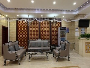 A lobby with a sofa set, a coffee table, and a refrigerator. - Greentree Alliance Hulunbeier Zhalantun Railway Station Hotel (Hulunbuir)