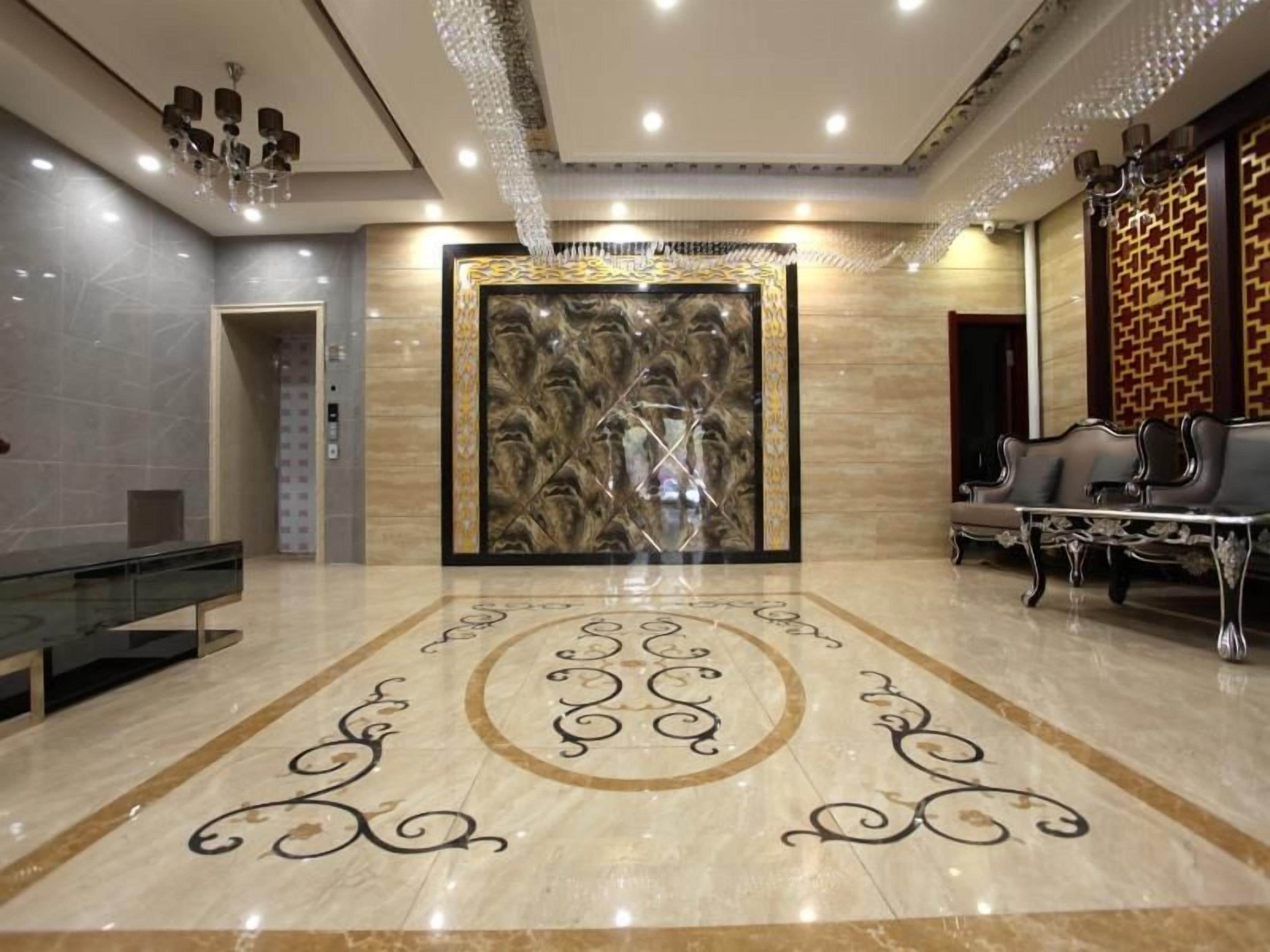 A spacious lobby with a marble floor, a large decorative wall, and a seating area with sofas.