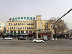 A hotel with multiple floors, a prominent entrance, and several visible storefronts. - Greentree Alliance Hulunbeier Zhalantun Railway Station Hotel (Hulunbuir)
