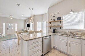 Enjoy cooking in this well-equipped kitchen with a central island, sink, and ample storage.