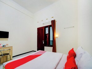 A hotel room with a bed, a desk, a chair, a television, and a window with curtains. - OYO 90151 Guest House 180 (Batu)