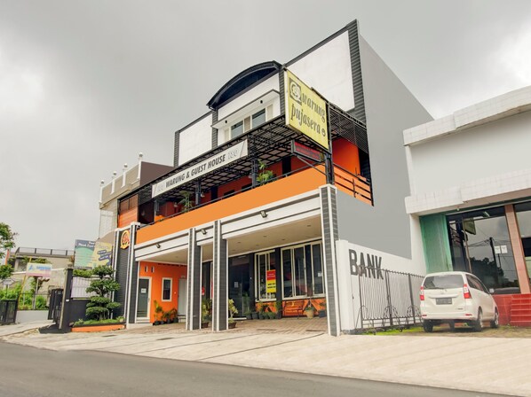 A two-story building with a sign for 'Warung Pujasera' and 'Warung & Guest House' on the upper level. - OYO 90151 Guest House 180 (Batu)