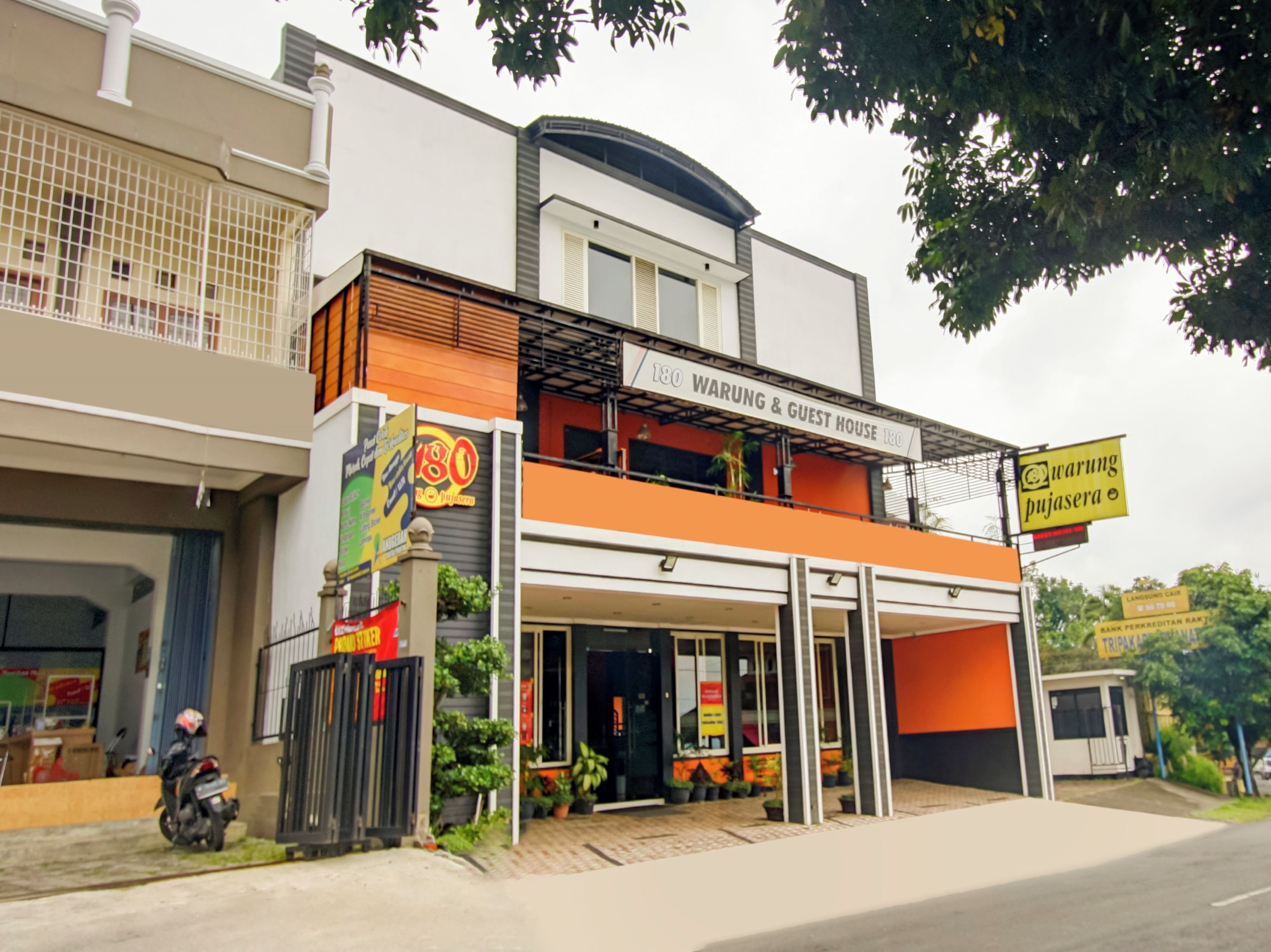 A two-story building with a sign for '180 Warung & Guest House.'