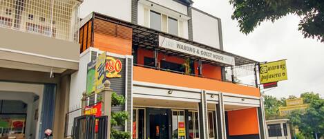 A two-story building with a sign for '180 Warung & Guest House.'