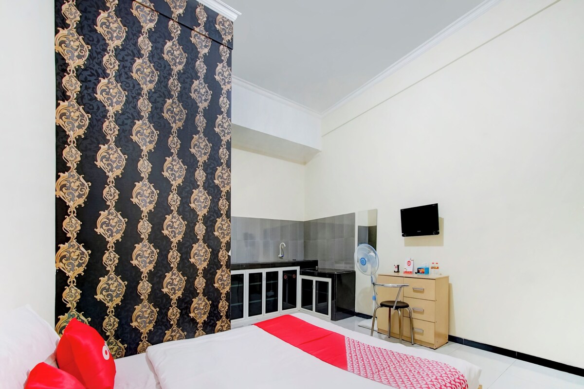 Une chambre d’hôtel équipée d’un lit, d’un bureau, d’une chaise, d’une télévision et d’une armoire.