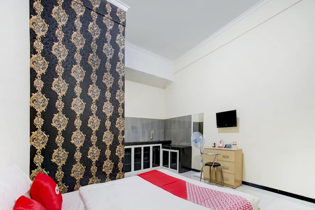 Hotellihuone, jossa on sänky, työpöytä, tuoli, televisio ja vaatekaappi.
