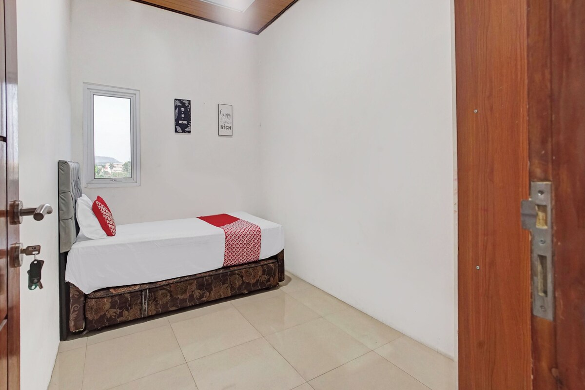 A bedroom with a bed, a window, and a door.