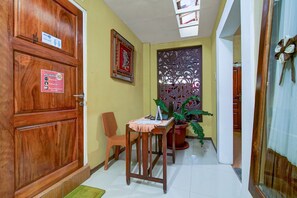 A wooden door with a sign indicating a 2-meter distance requirement. - OYO 90061 Melati House Syariah (Kepanjen)