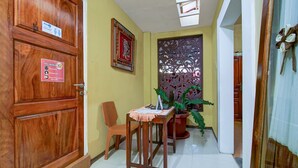 Une porte en bois portant une pancarte indiquant qu’il faut respecter une distance de 2 mètres.