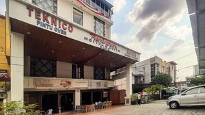 Un bâtiment sur lequel on peut lire les inscriptions « Teknico Pintu Oven » et « Fenwick Hostel & Cafe ».