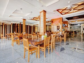 Une salle à manger spacieuse avec de hauts plafonds, des meubles en bois et un plancher ciré.