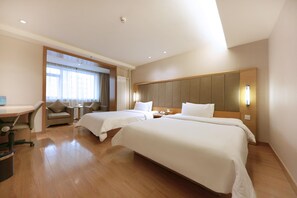 Habitación de hotel con dos camas, un escritorio, una silla y vista al exterior.
