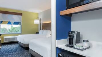 Quarto de hotel com duas camas, janela com vista, minibar e micro-ondas.