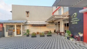 A courtyard with a coffee shop named "Coffee & Herb" and a sign for "Grina Amanah Jajar." - OYO Capital O 90410 Griya Amanah Jajar Syariah (Surakarta)