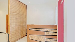 A reception desk with a wooden finish and a black metal frame. - OYO Capital O 90410 Griya Amanah Jajar Syariah (Surakarta)