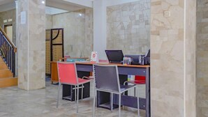 A study area with a desk, two chairs, and a laptop. - OYO 90035 Merci Club (Bandung)