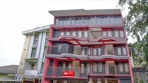 A multi-story hotel with balconies, a prominent red sign, and a modern architectural design. - OYO 90035 Merci Club (Bandung)