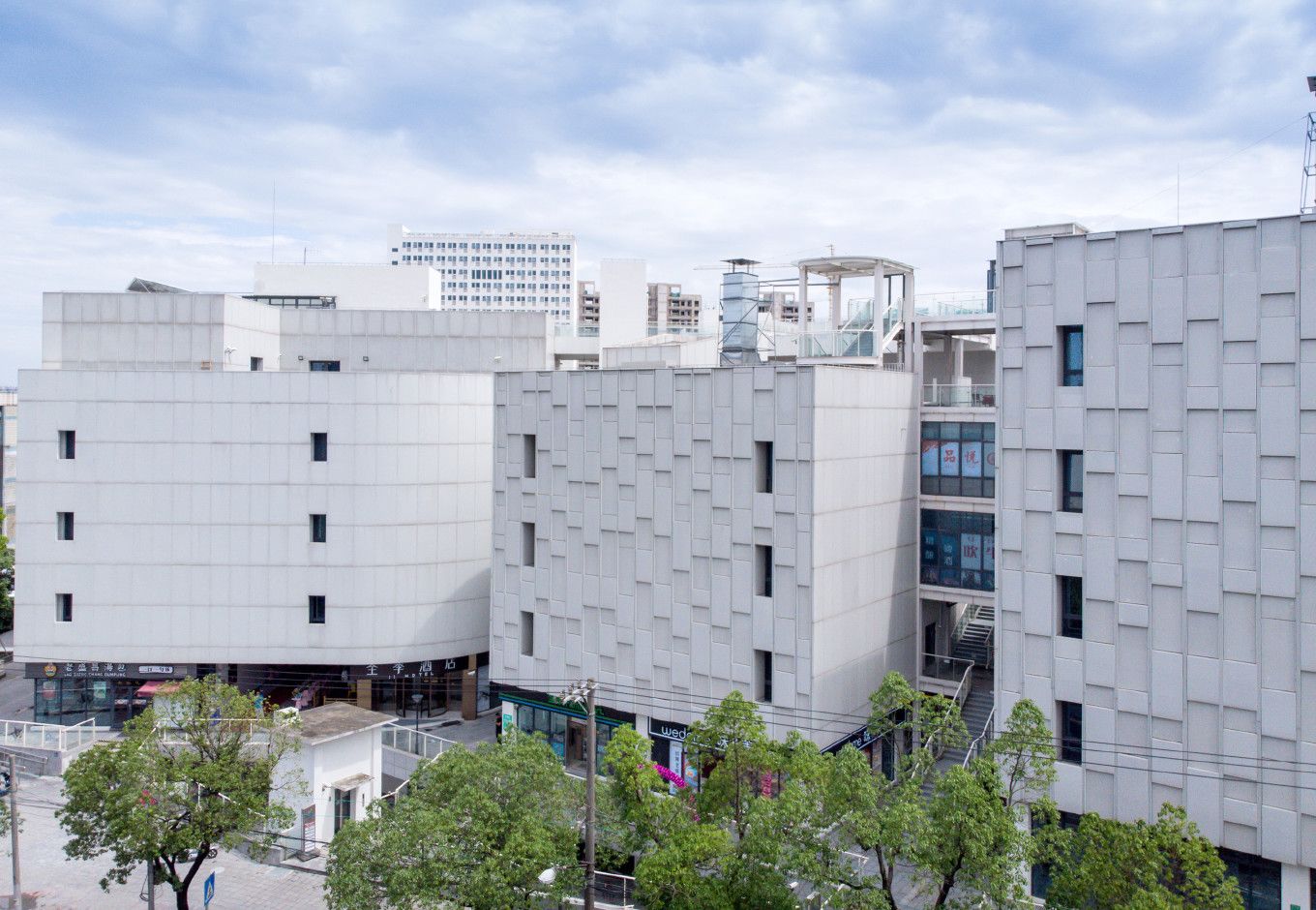 A modern building with a grid-like facade, multiple windows, and a visible entrance.