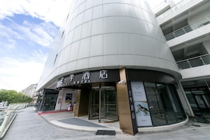 A hotel with a modern design, featuring a curved facade and large glass windows.