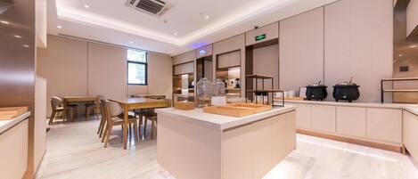A modern kitchen with a central island, built-in appliances, and a dining area with wooden furniture.