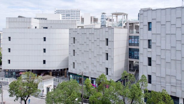 A modern building with a grid-like facade, multiple windows, and a visible entrance. - Ji Hotel (Shanghai)