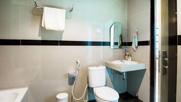 A bathroom with a toilet, sink, and shower.