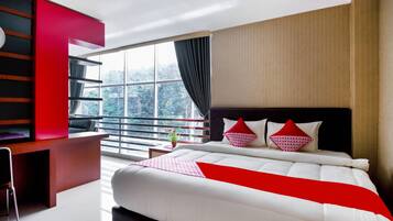 A modern hotel room with a large bed, a desk, and a balcony with a view.