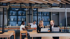 Eine moderne Bar mit Holzelementen, einer Theke und Regalen voller Flaschen.